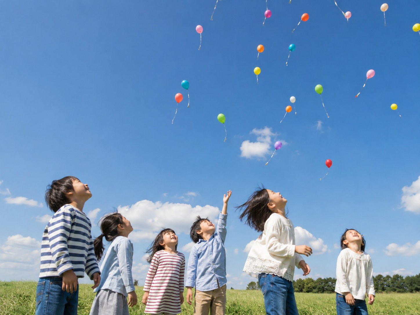 空へ舞い上がる風船を見上げる子どもたち