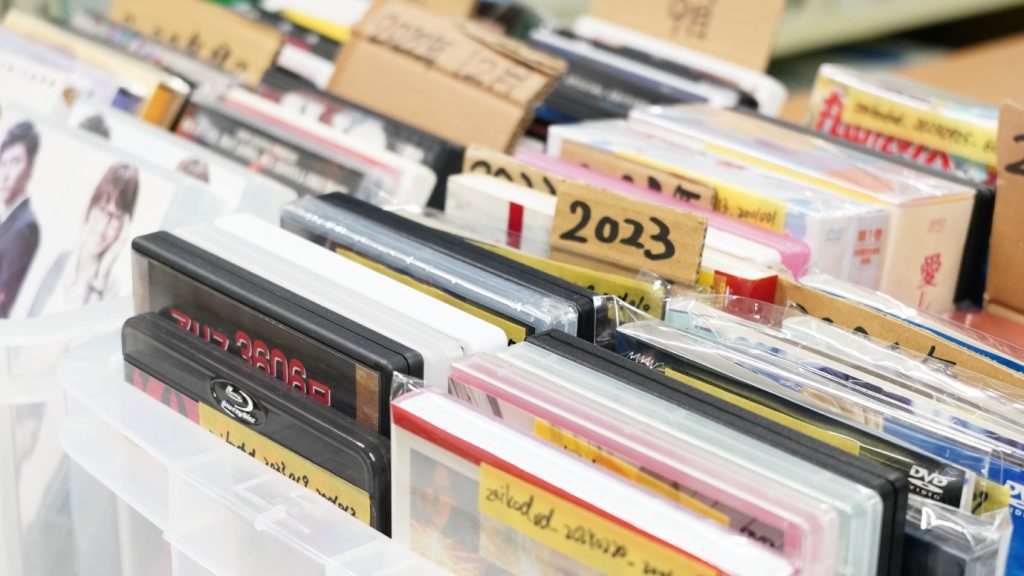 リユース事業の倉庫。書籍がジャンルごとに並ぶ在庫棚